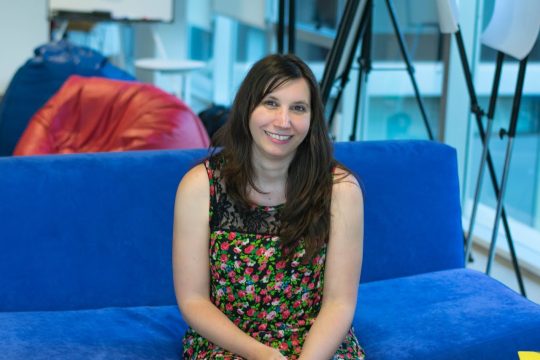 Celeste sitting in a couch smiling